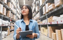 Young asian woman stocktaking inventory in a warehouse