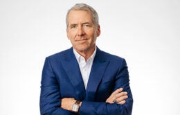 UC President James B. Milliken with his arms folded across his chest