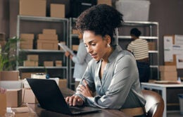 Supply chain staff, person or tech in warehouse for inventory control, procurement email or update.