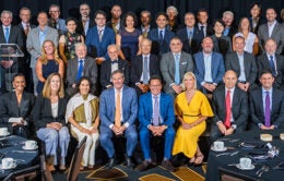 Large group of people posed together in four rows