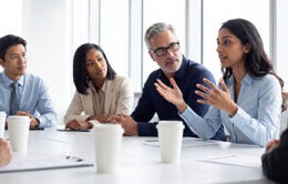 This dynamic photograph captures a diverse team collaborating and sharing ideas during an important corporate meeting.