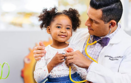 UC doctor listening to a child's heartbeat