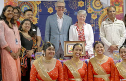 Group of smiling people, some wearing Southeast Asian attire